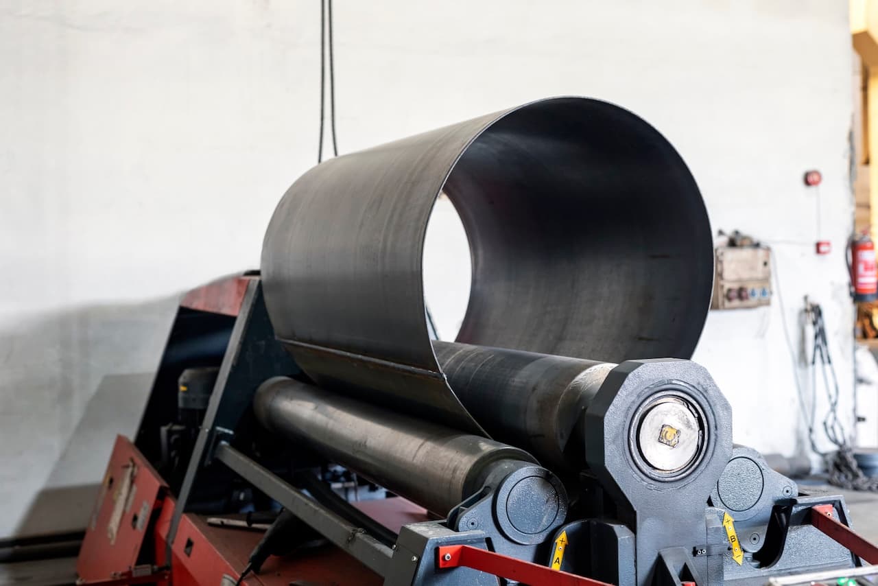 Máquina industrial para el procesamiento de tuberías de acero en un entorno de taller.