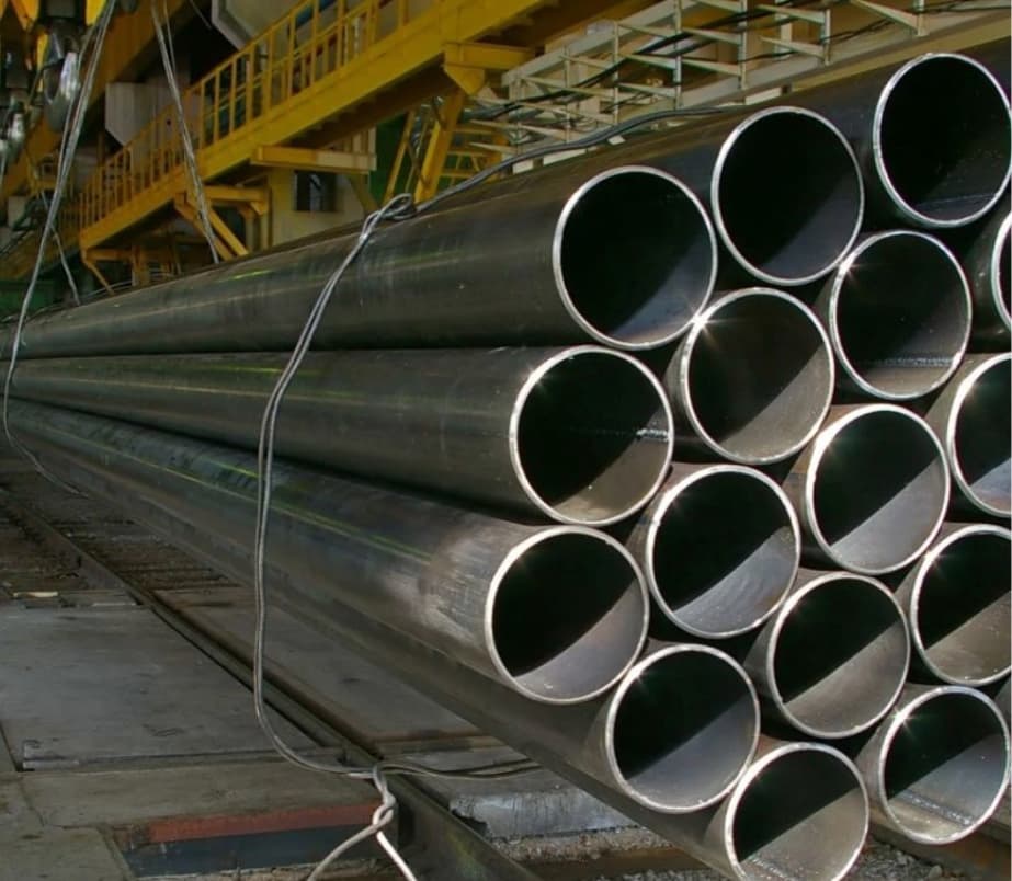 Tuberías de acero apiladas en un entorno industrial.